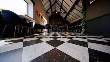 Um interior amplo com piso xadrez, tetos altos e áreas de estar.