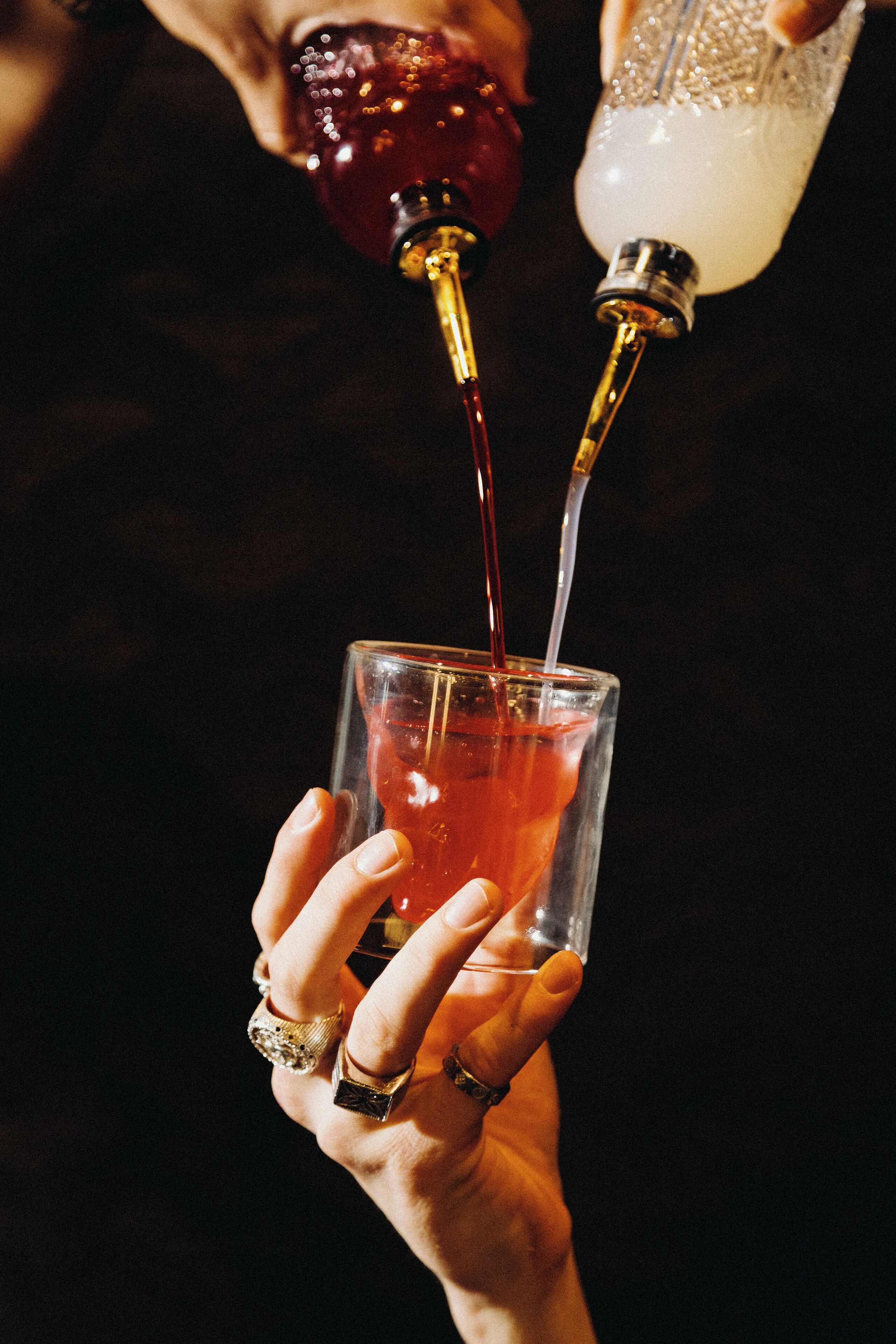 A person pouring a drink into a glass.