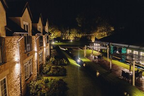 A courtyard with a covered outdoor seating area, a lawn, and a building with a brick facade. - The Chesterton Hotel (Bicester)