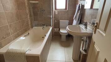 A bathroom with a bathtub, toilet, and sink.