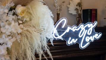A neon sign with the text "Crazy in Love" in a cursive font, placed on a dark wooden surface.