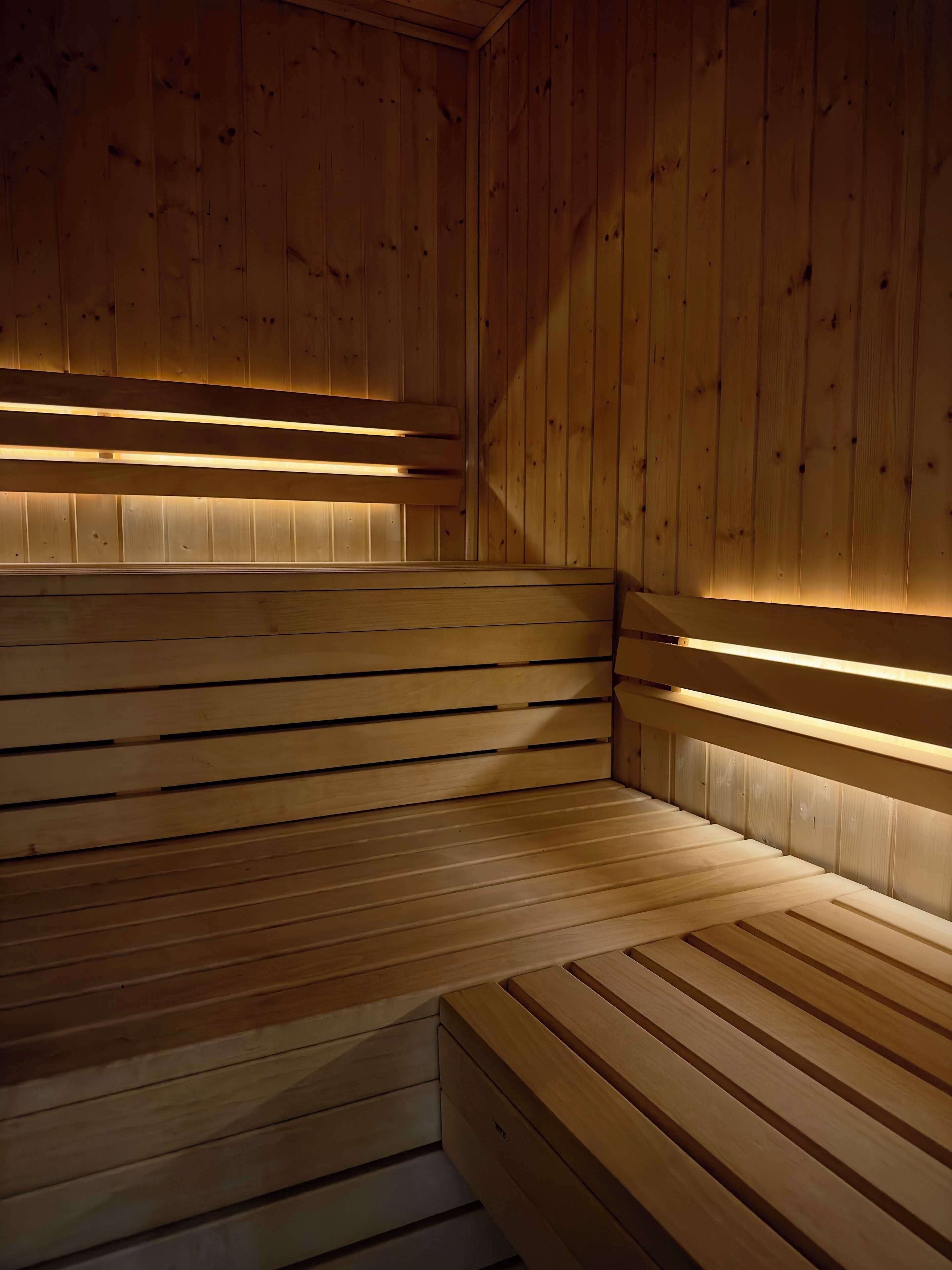 A wooden sauna with benches and slatted walls.