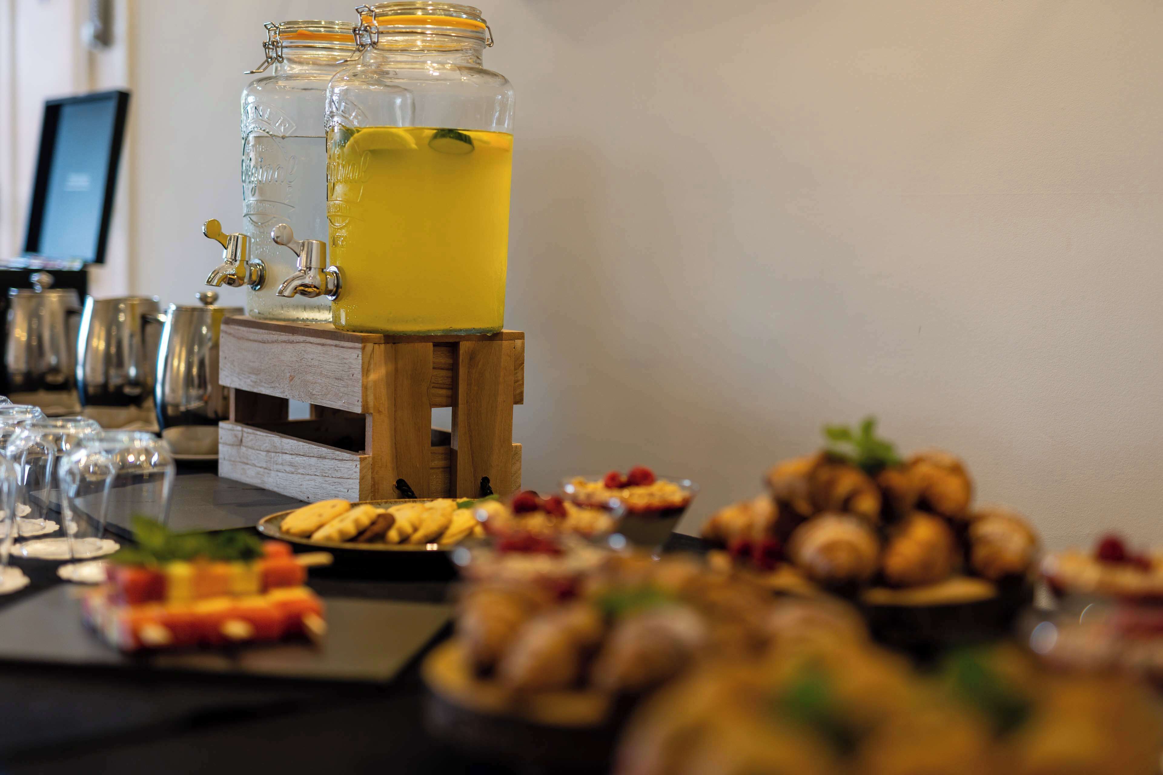A buffet table with various food items and a beverage dispenser.