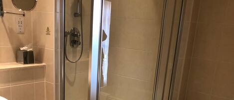 Un baño moderno con ducha de vidrio, bañera, inodoro y lavamanos.