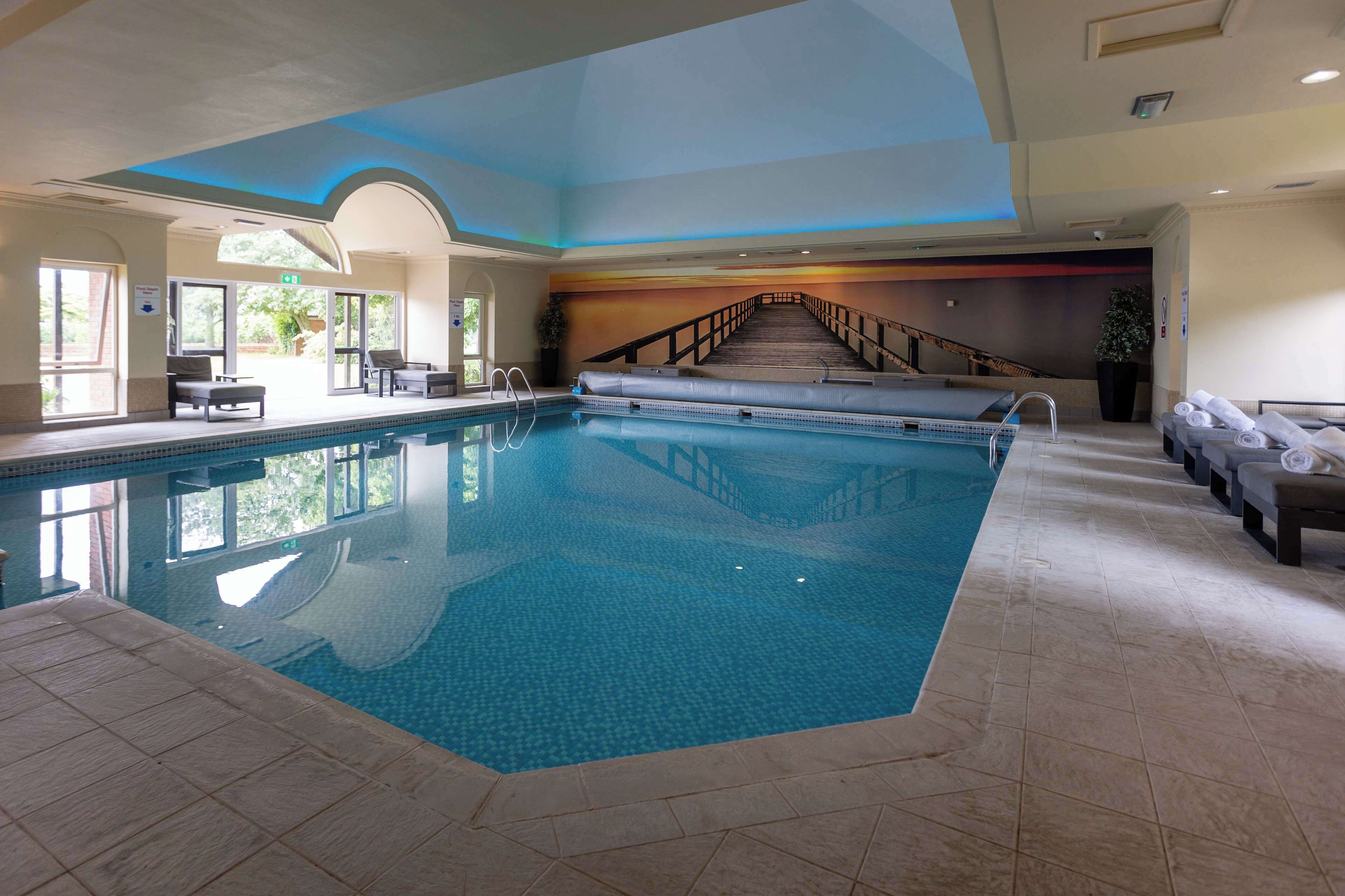 An indoor swimming pool with a clear view of the stairs leading to the upper level.