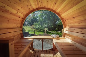 Eine Holzsauna mit Bänken und einem Rundfenster.