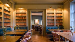 Una biblioteca con estanterías, mesas y sillas.