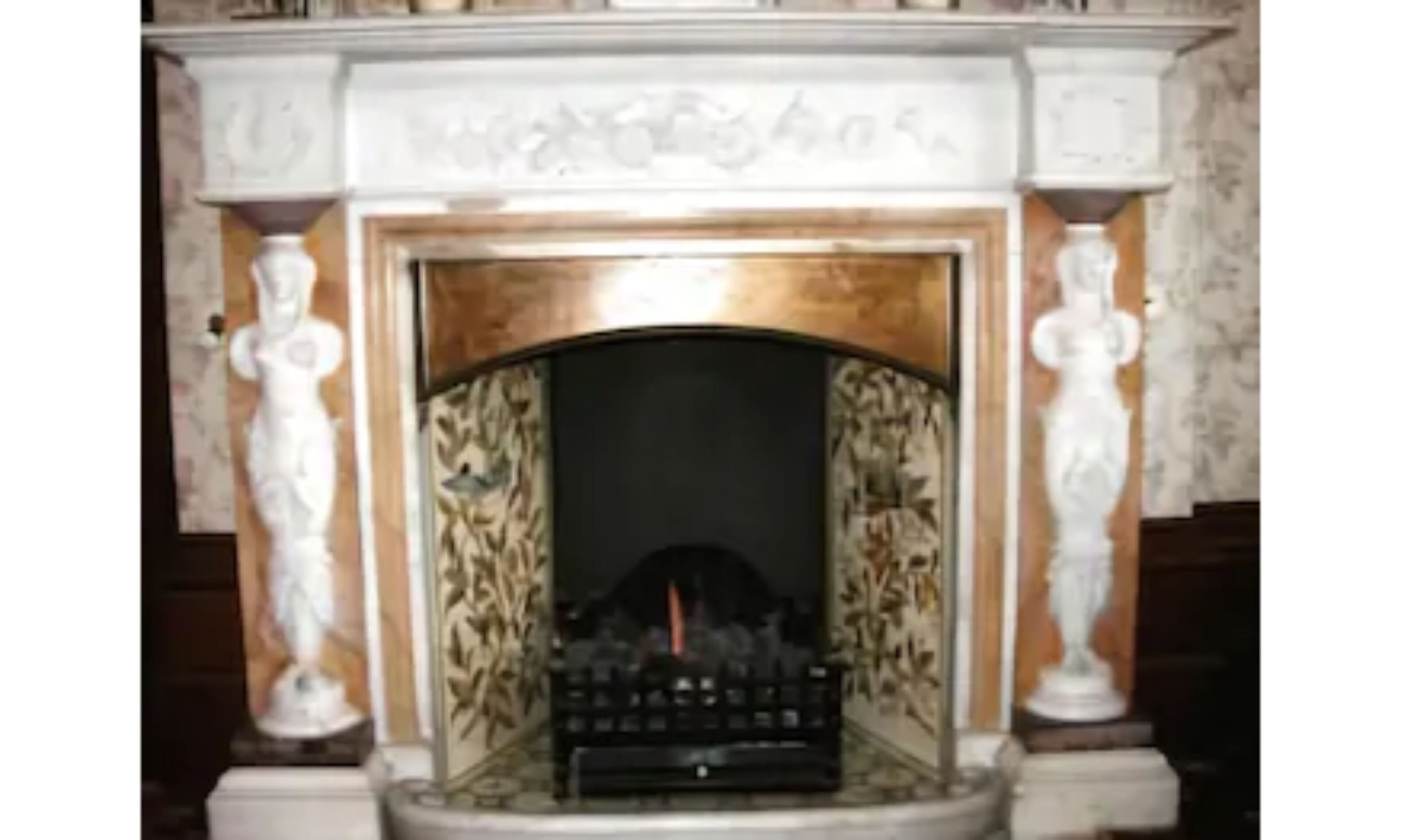 A fireplace with a decorative mantel and a central fire.