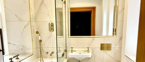 A bathroom with a freestanding bathtub, a sink, a toilet, and a large mirror.