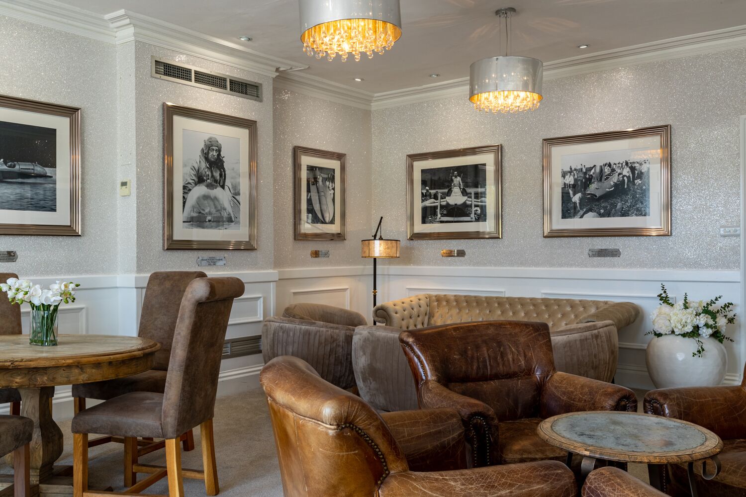 Un salon luxueux avec des fauteuils en cuir, une table ronde et un canapé.