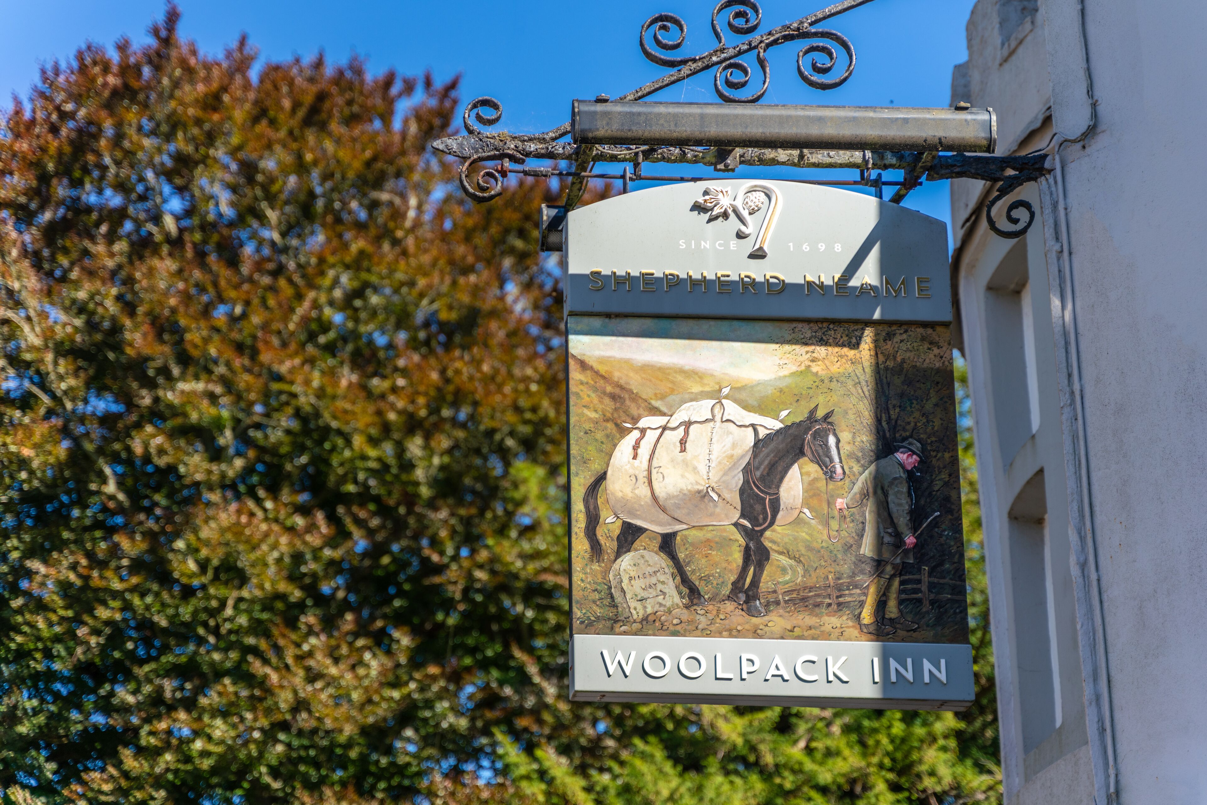 Une enseigne représentant un cheval et un cavalier, placée devant l’auberge Woolpack Inn.