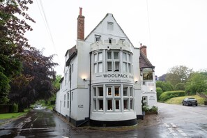A white building with a sign reading "WOOLPACK INN" and "Chillham".
