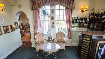 A room with a dining area, a bar, and a view of the outside.