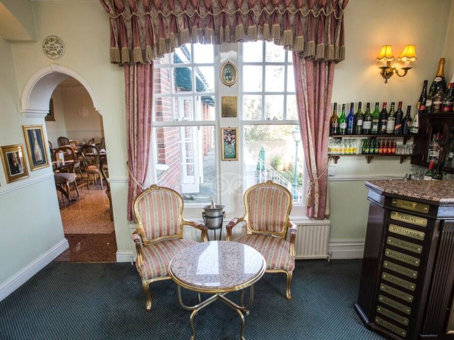 A room with a dining area, a bar, and a view of the outside.