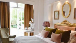 A hotel room with a large bed, a chair, a table with a lamp, and a window with curtains. - The Lookout Rye (Rye)