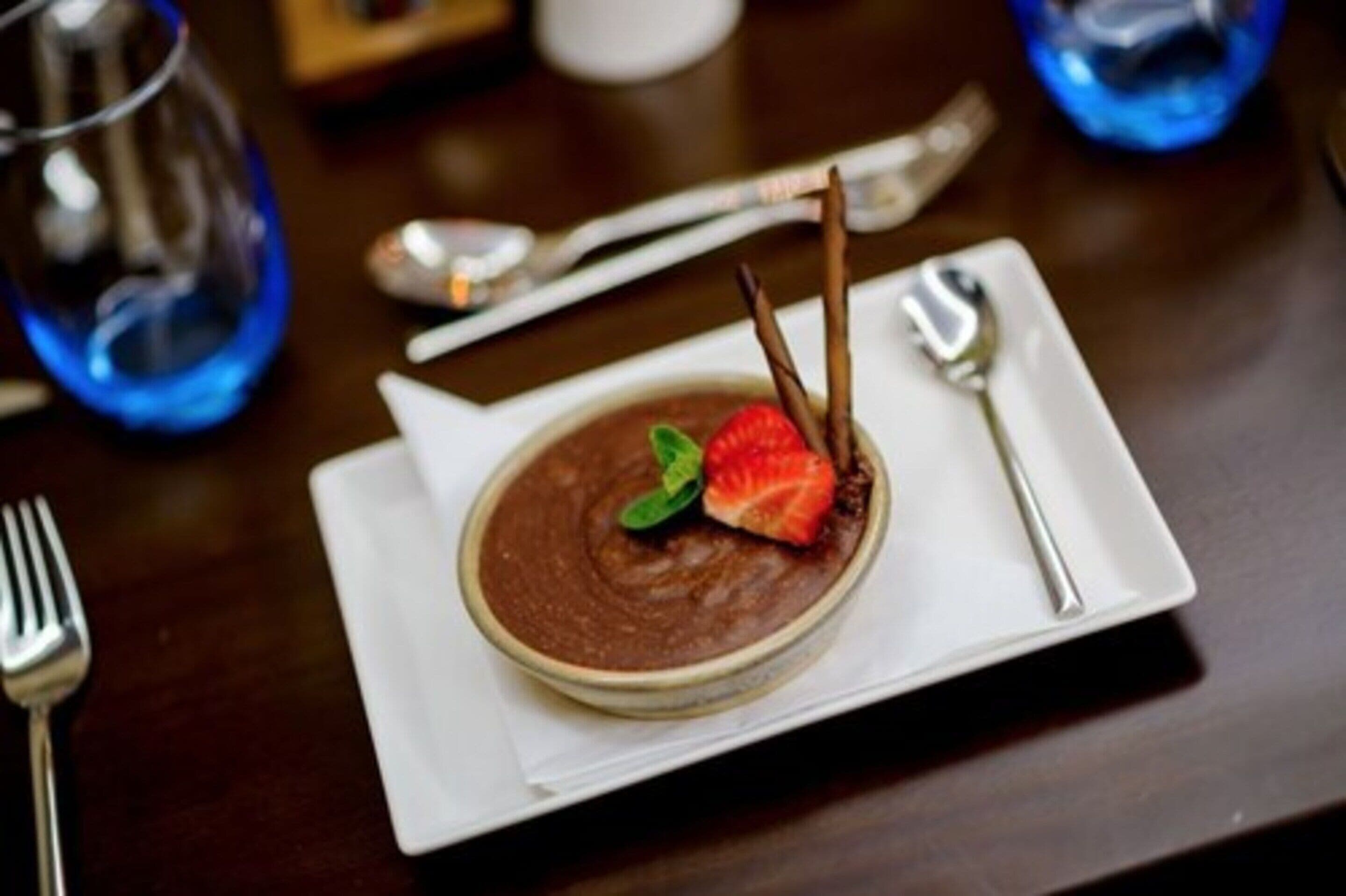 Un dessert servi dans une assiette blanche, avec une fourchette et une cuillère à côté.