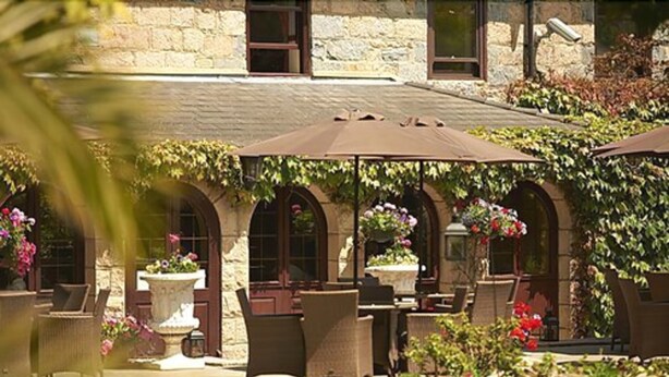 A stone building with outdoor seating and potted plants. - Le Friquet Country Hotel (Castel)