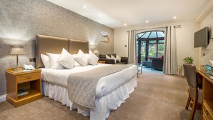 A spacious bedroom with a large bed, a desk, and a view of the outdoors. - Le Friquet Country Hotel (Castel)