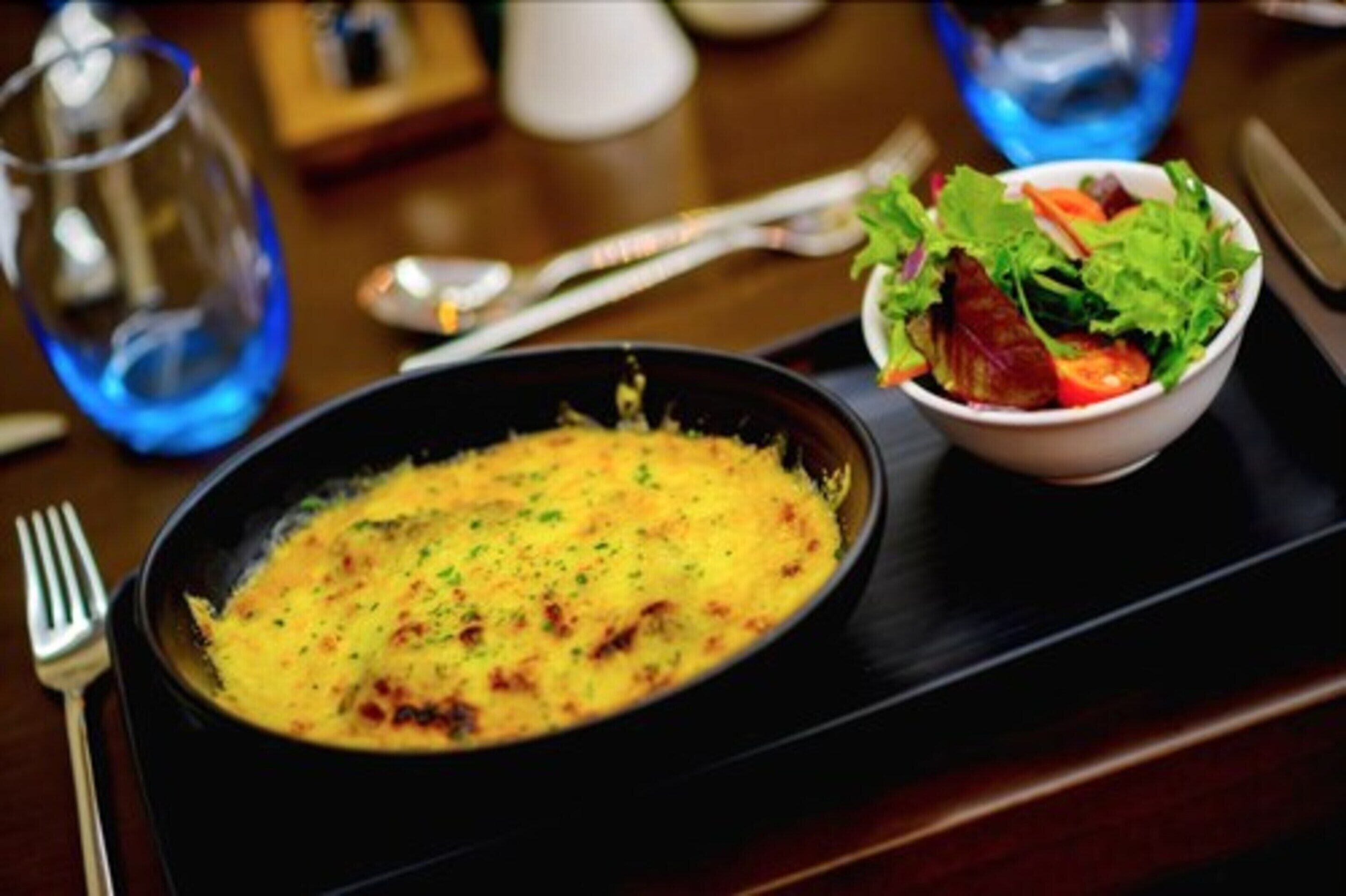 A breakfast tray with a plate of scrambled eggs and a side salad.