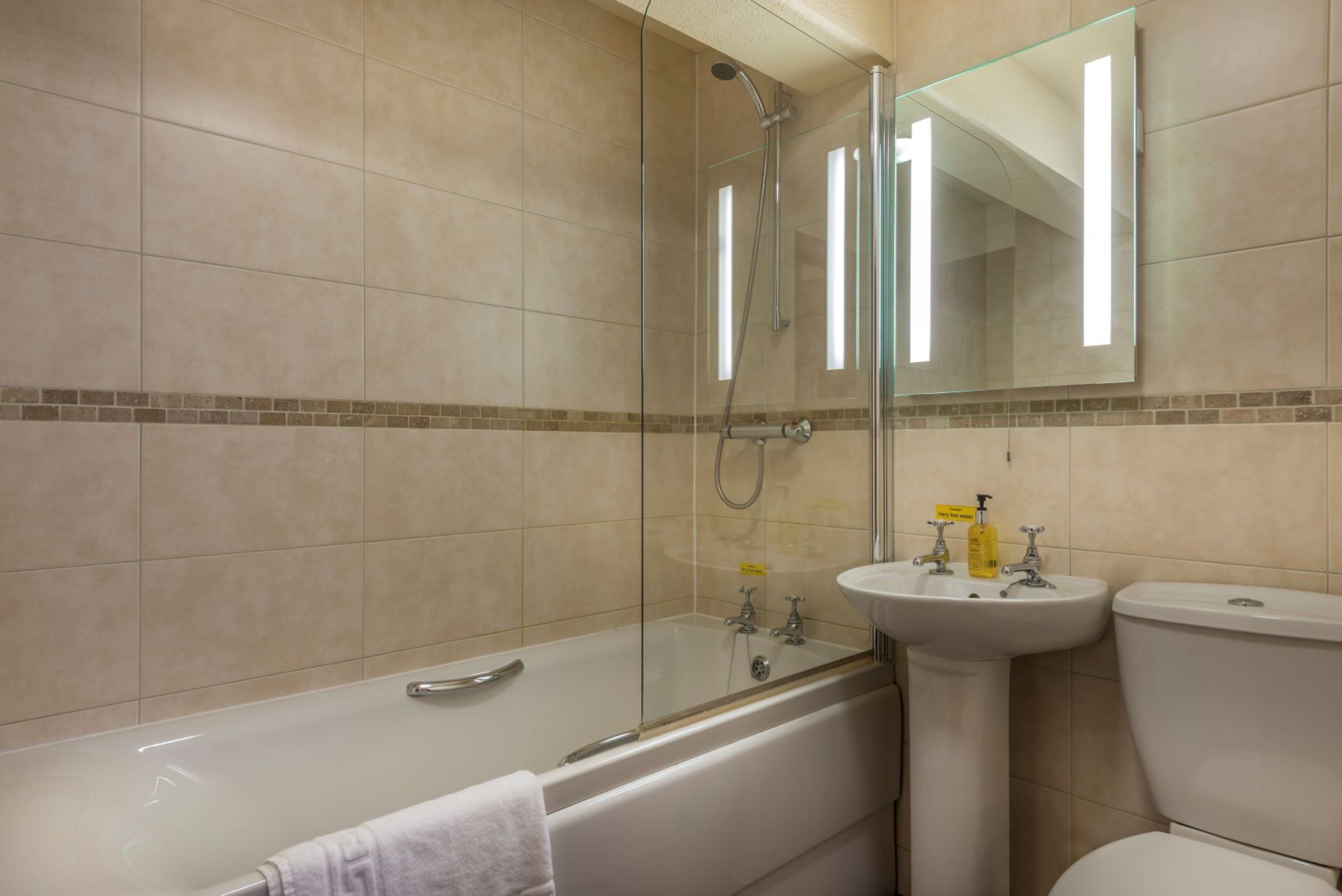 Une salle de bain avec une douche à parois de verre, une baignoire, un lavabo et des toilettes.
