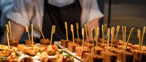 A variety of appetizers arranged on trays, including bread cubes and meatballs, with toothpicks inserted.