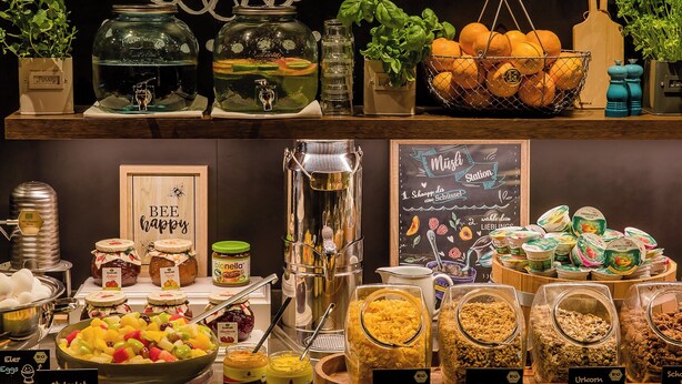 Un buffet proposant une variété de plats, notamment des fruits, des salades et des céréales.