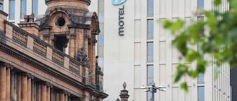 Historiallinen rakennus, jonka tunnusomaisena piirteenä on sen suuri kupoli, sekä sen viereinen moderni rakennus, jonka nimikylteissä lukee ”Piccadilly Place” ja ”Motel One”.