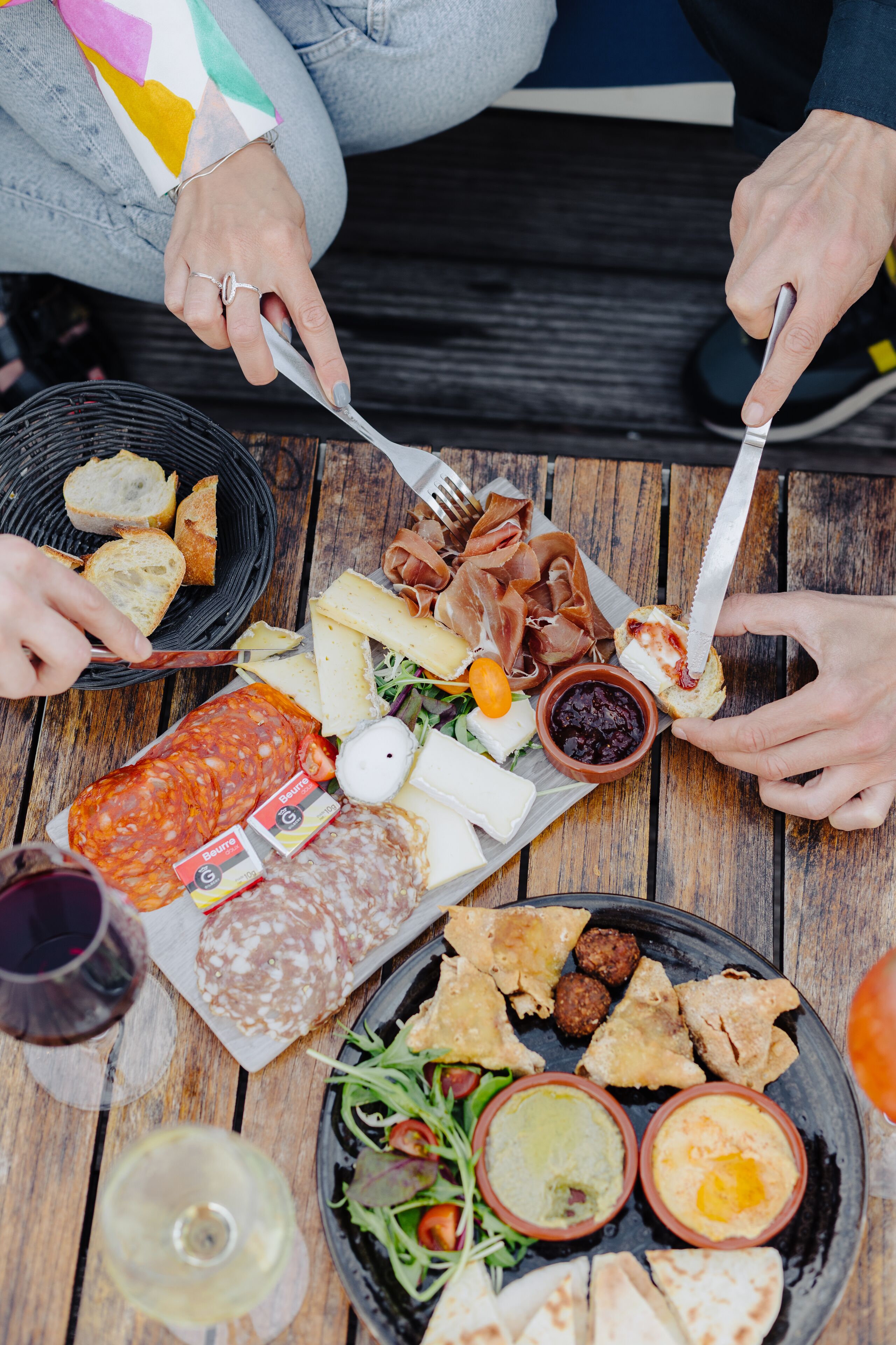 A wooden table with various food items and drinks.