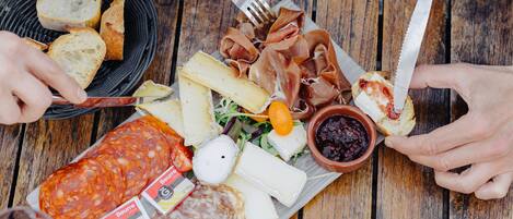 A wooden table with various food items and drinks.