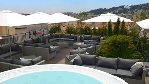 A rooftop terrace with outdoor seating, a hot tub, and umbrellas. - Hôtel & Appartements Monsigny (Nice)
