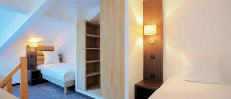 A modern bedroom with a loft-style bed, built-in wooden shelving, and a wall-mounted reading light.