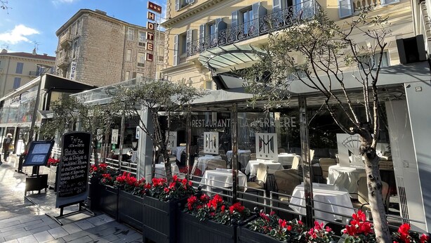 A hotel with a restaurant patio, outdoor seating, and a sign indicating a restaurant. - Hôtel & Appartements Monsigny (Nice)