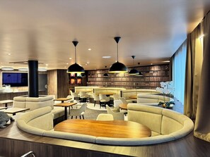 A modern lounge area with sofas, tables, and pendant lighting. - Hôtel & Appartements Monsigny (Nice)