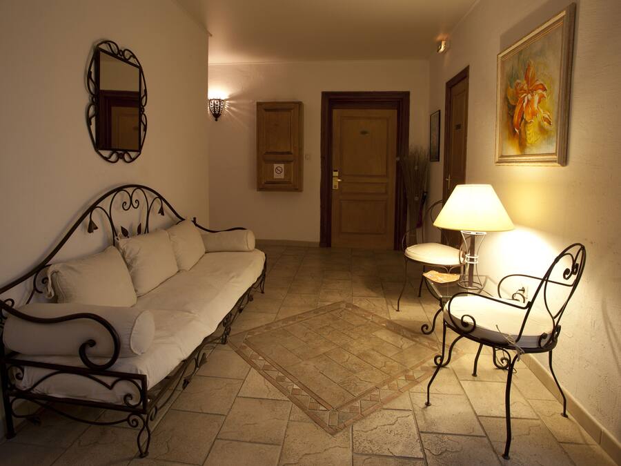Una habitación acogedora con un sofá, una silla, una lámpara y un cuadro en la pared.
