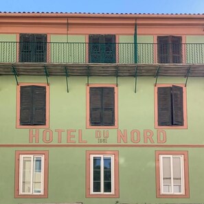 A building with the sign 'HOTEL DU NORD' and the year '1861' indicating its establishment. - Hotel du Nord (Corte)