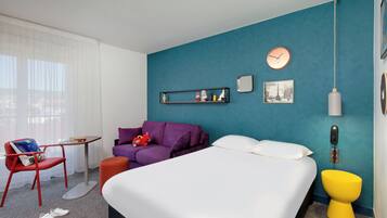 Relax in a stylish space with a large bed, sofa, and comfortable seating area.