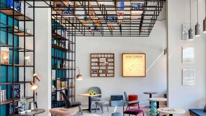 Un interior moderno con una estantería, zona de estar y obras de arte.