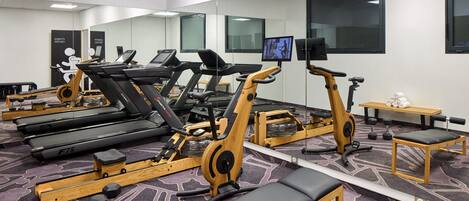 A gym with treadmills, elliptical machines, and free weights.