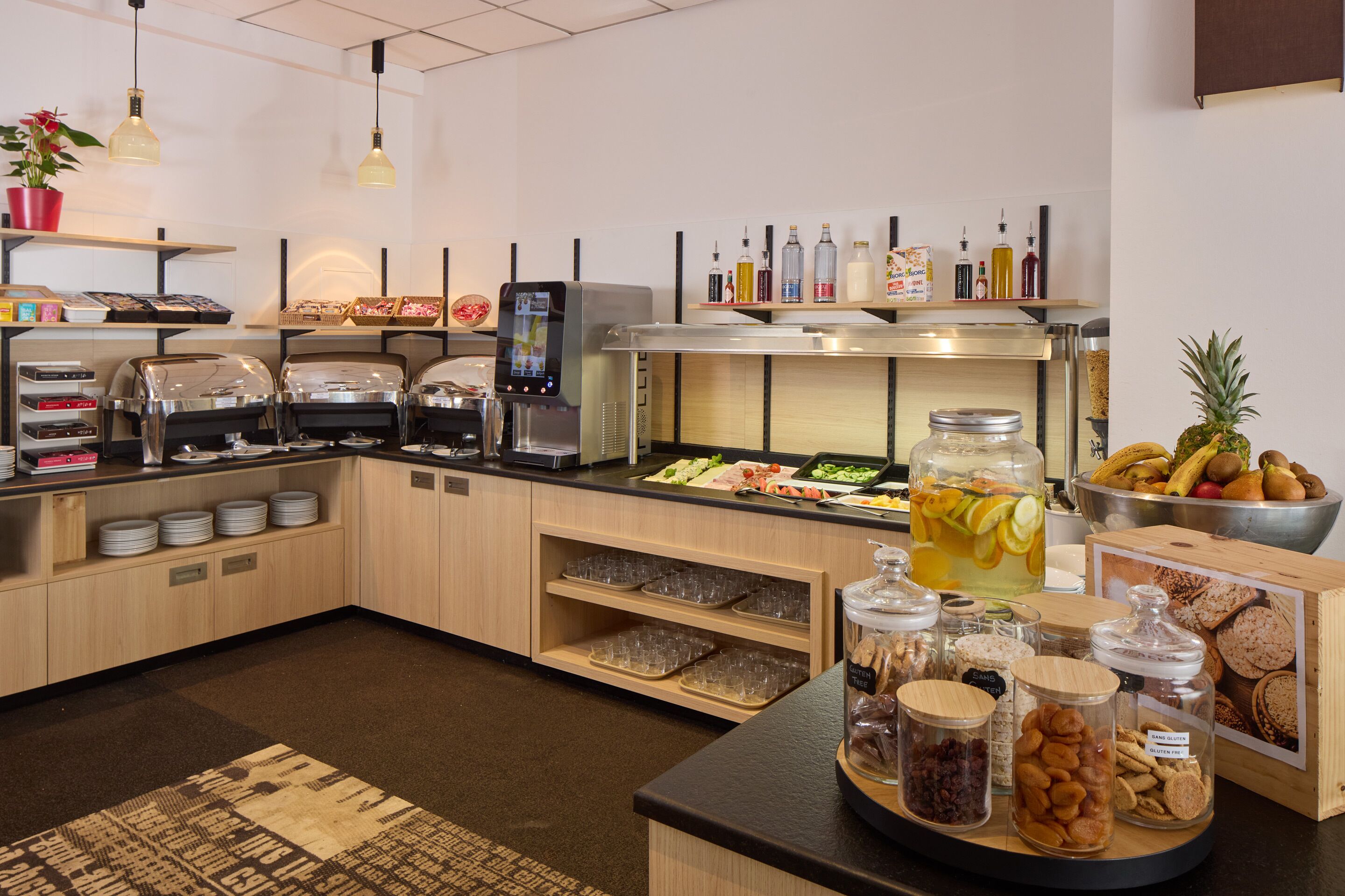 A buffet setup with various food items, a coffee machine, and condiment dispensers.