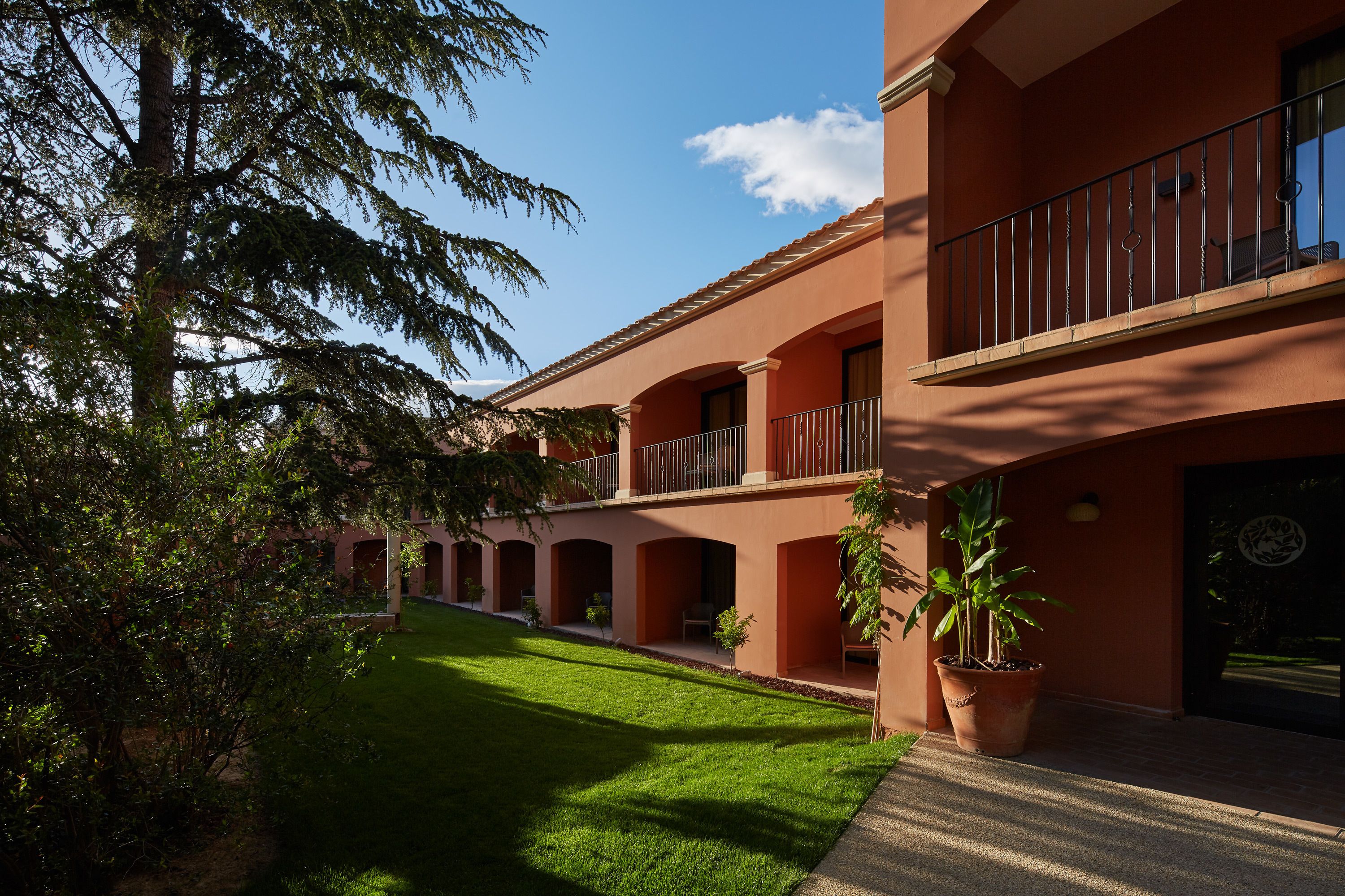 Un edificio con un patio, un balcón y una planta en maceta.