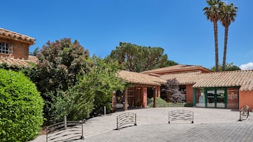 Un patio con techo de tejas, palmeras y un edificio con un letrero que dice "NUKE 308".