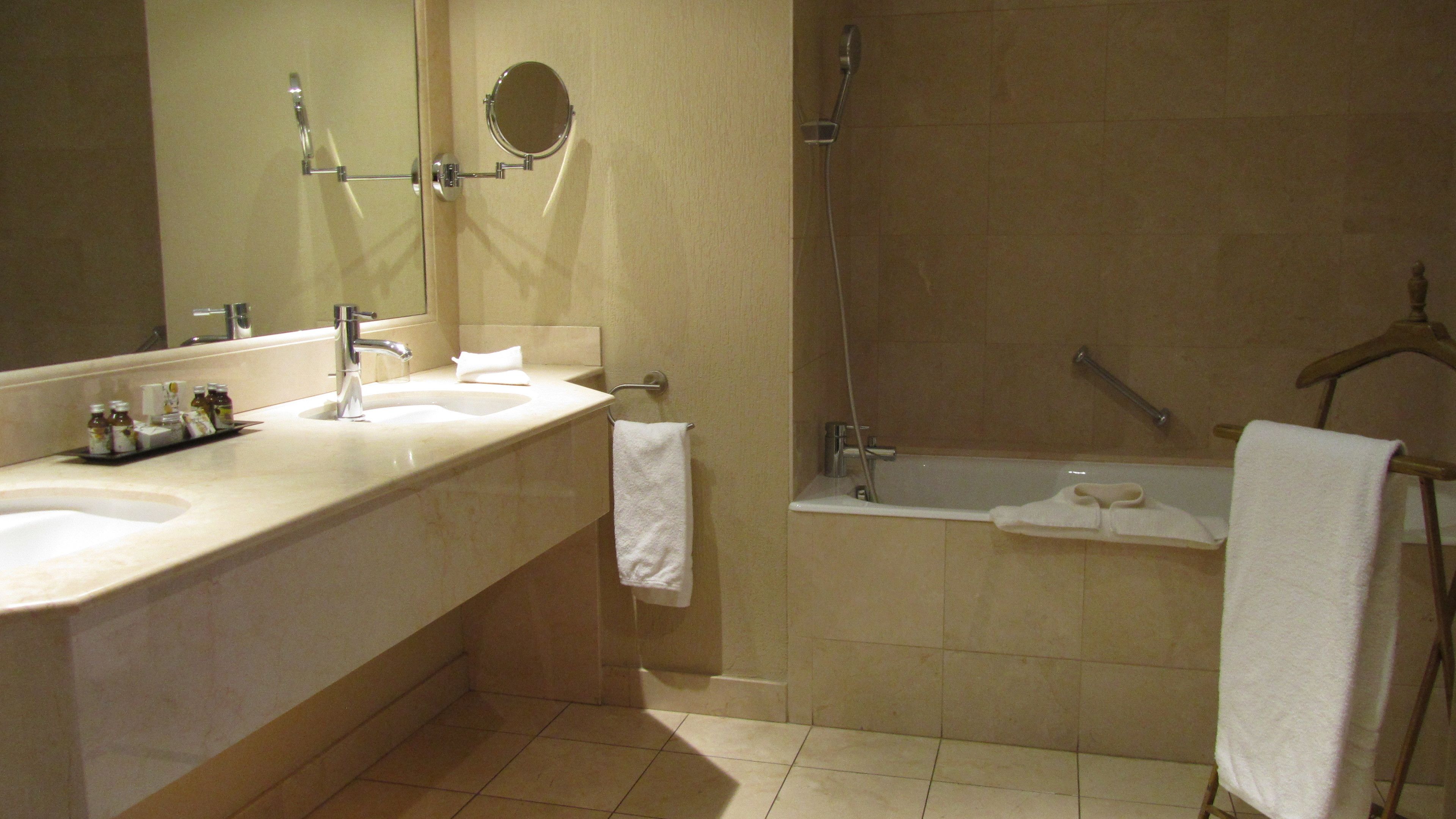 A bathroom with a sink, mirror, and shower.
