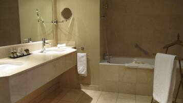 A bathroom with a sink, mirror, and shower.