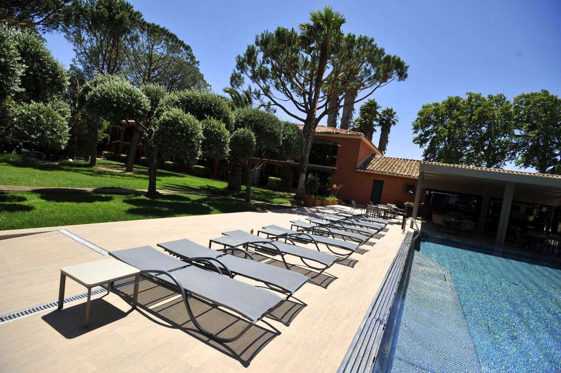 A poolside area with lounge chairs and a swimming pool.