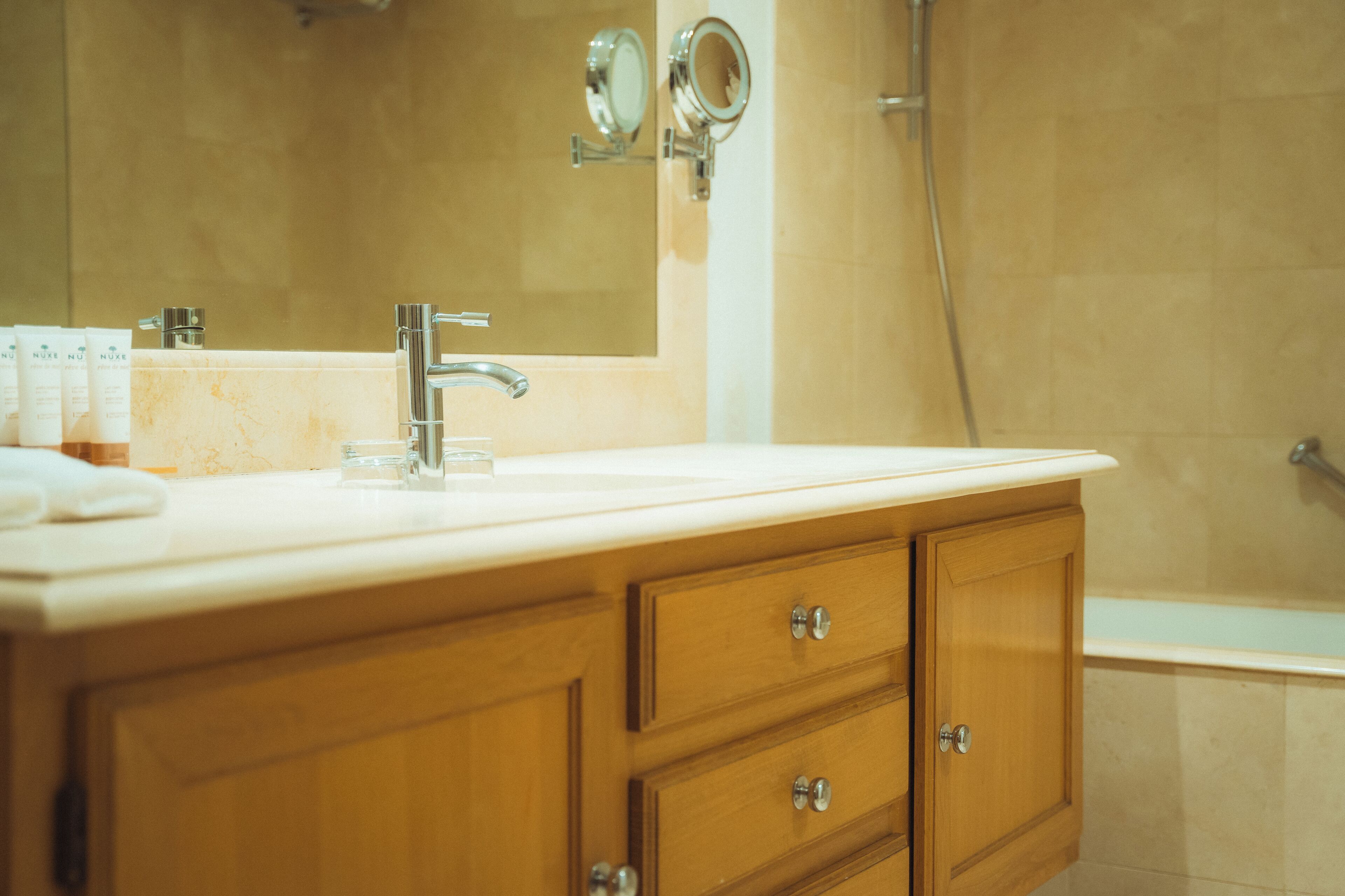Un baño con lavamanos, espejo y ducha.