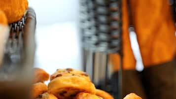 A tray of pastries, including croissants and muffins, in a kitchen setting.