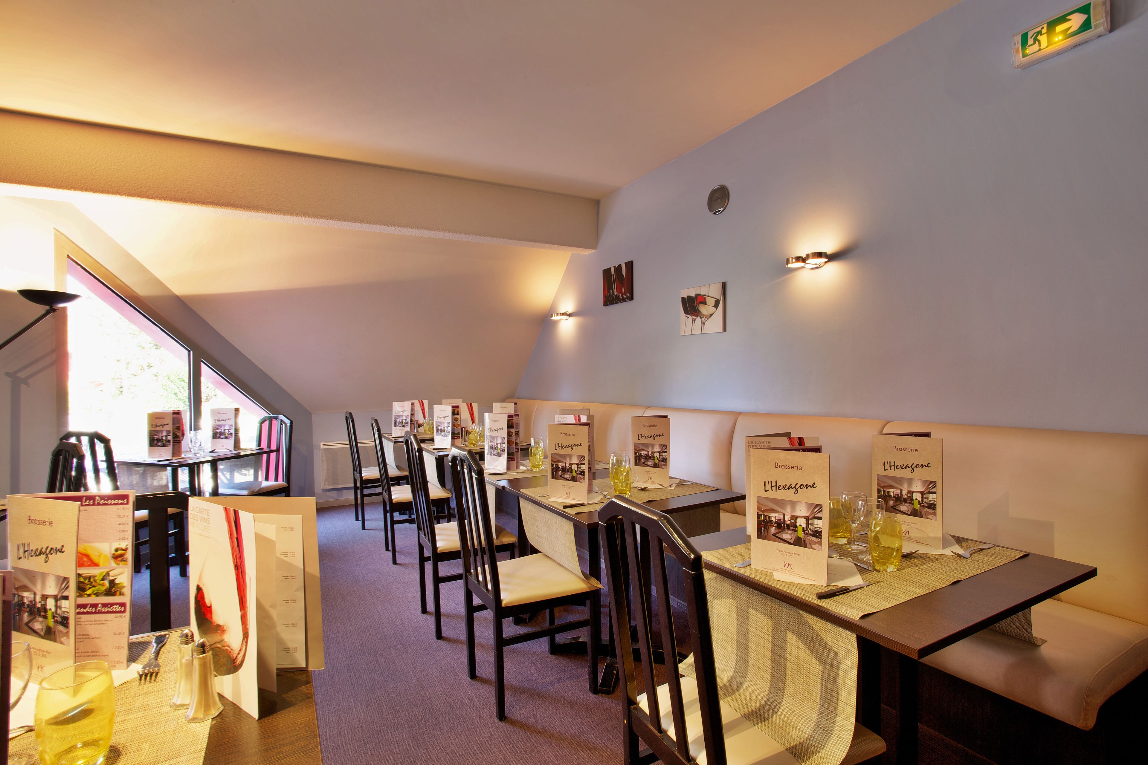 Een restaurant met hoge tafels, stoelen en menukaarten.