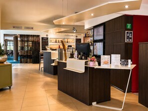 Ein Hotel-Empfangsbereich mit einer Rezeption, einem Computer und einer Speisekarte.