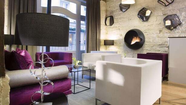 Un salon moderne avec un mur en pierre, une cheminée et des meubles contemporains.