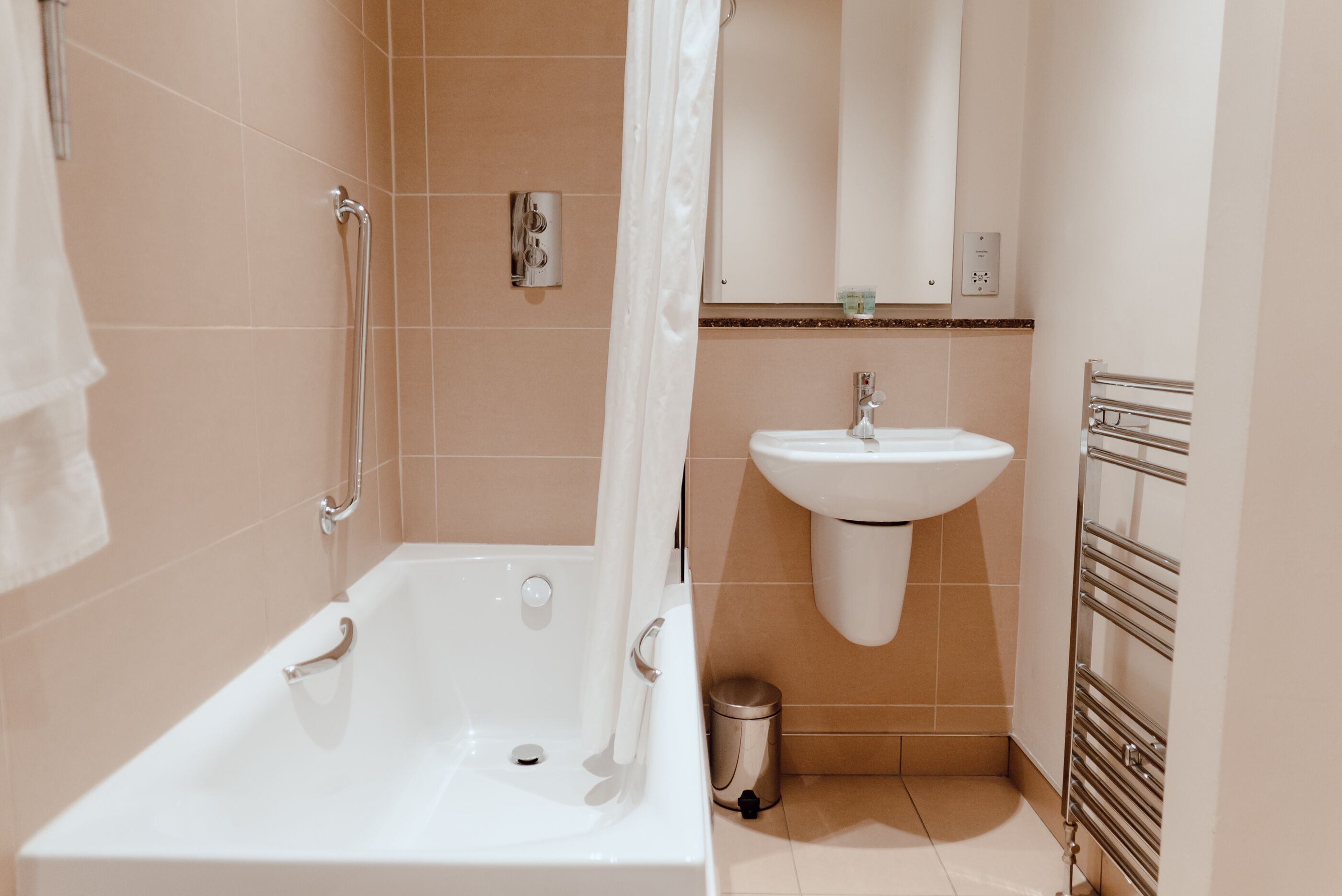 A modern bathroom with a bathtub, a sink, and a shower area.